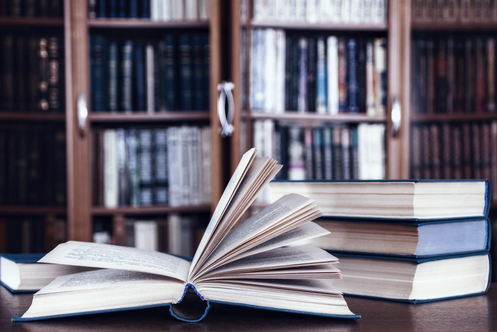 Books lie on the table against the background of bookcases