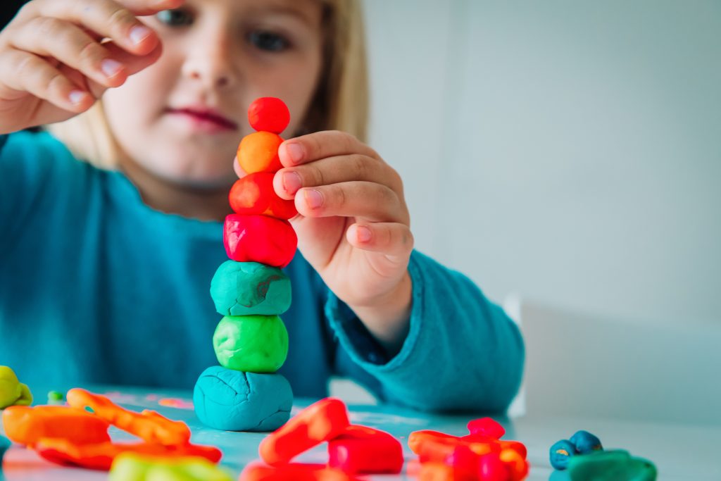 Child playing with clay molding shapes, kids crafts