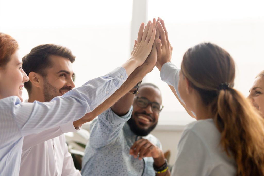 Multiracial associate business people group teammates hands give high five together promising unity as dream team concept, corporate success, teambuilding and loyalty, support in teamwork, coaching