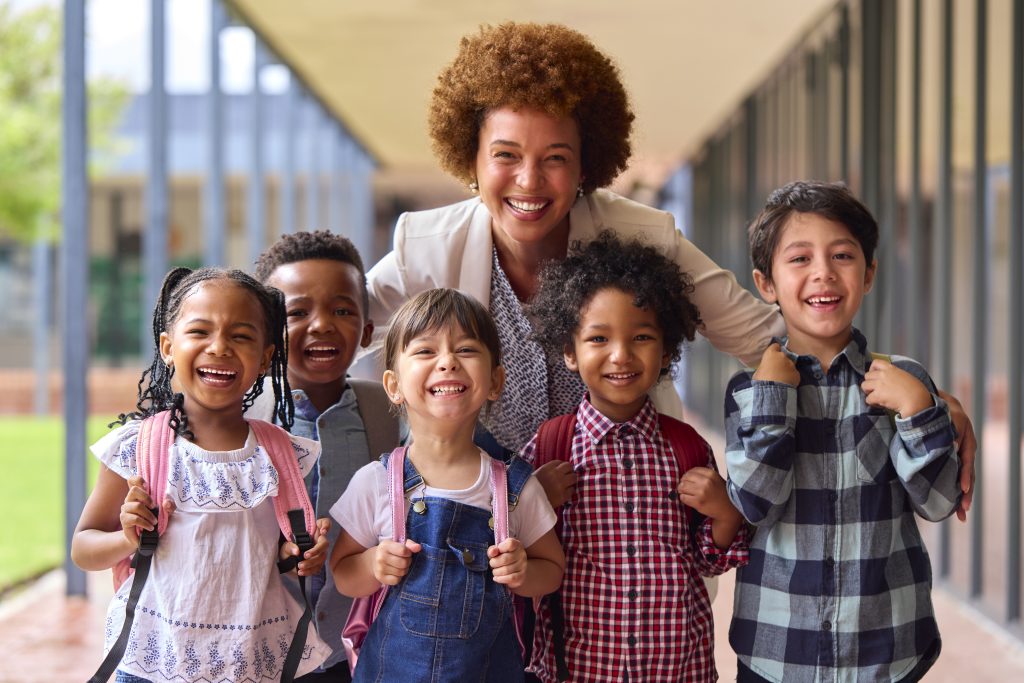 Portrait Of Multi-Cultural Elementary School Pupils With Female Teacher Outdoors At School