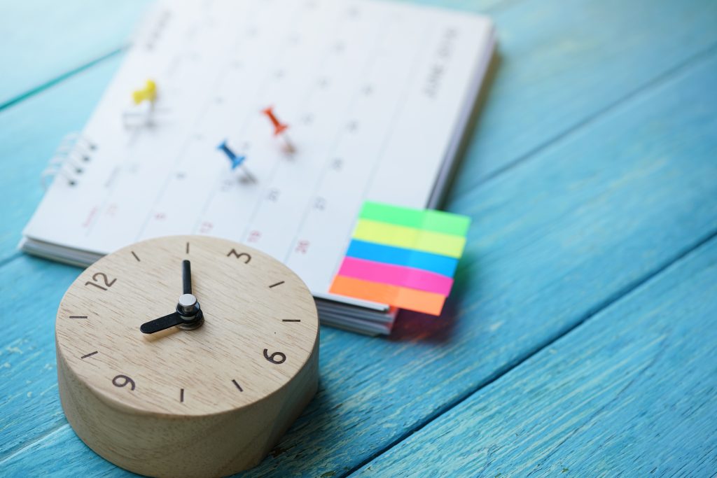 close up of calendar and clock on the table, planning for business meeting or travel planning concept