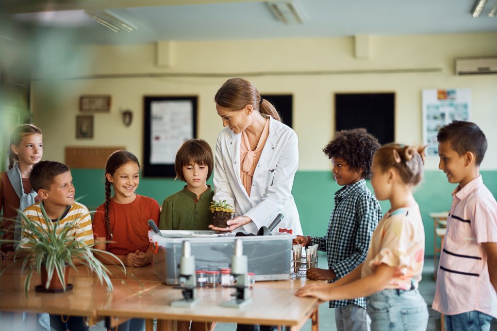 Group of elementary students having botany class with their science teacher in the classroom.