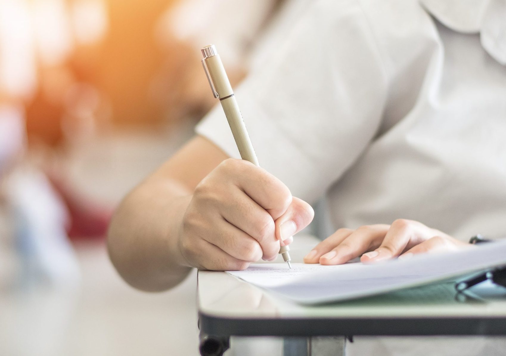 Exam with school student having a educational test, thinking hard, writing answer in classroom for  university education admission and world literacy day concept