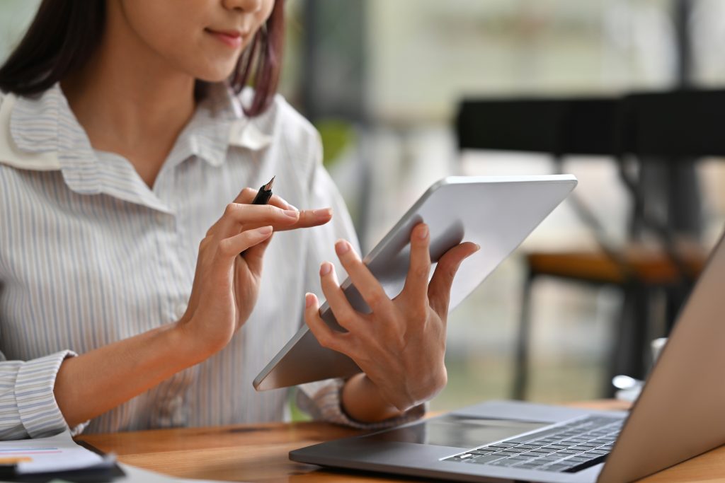 Close up or cropped image of Business and financial woman using tablet and laptop for working.