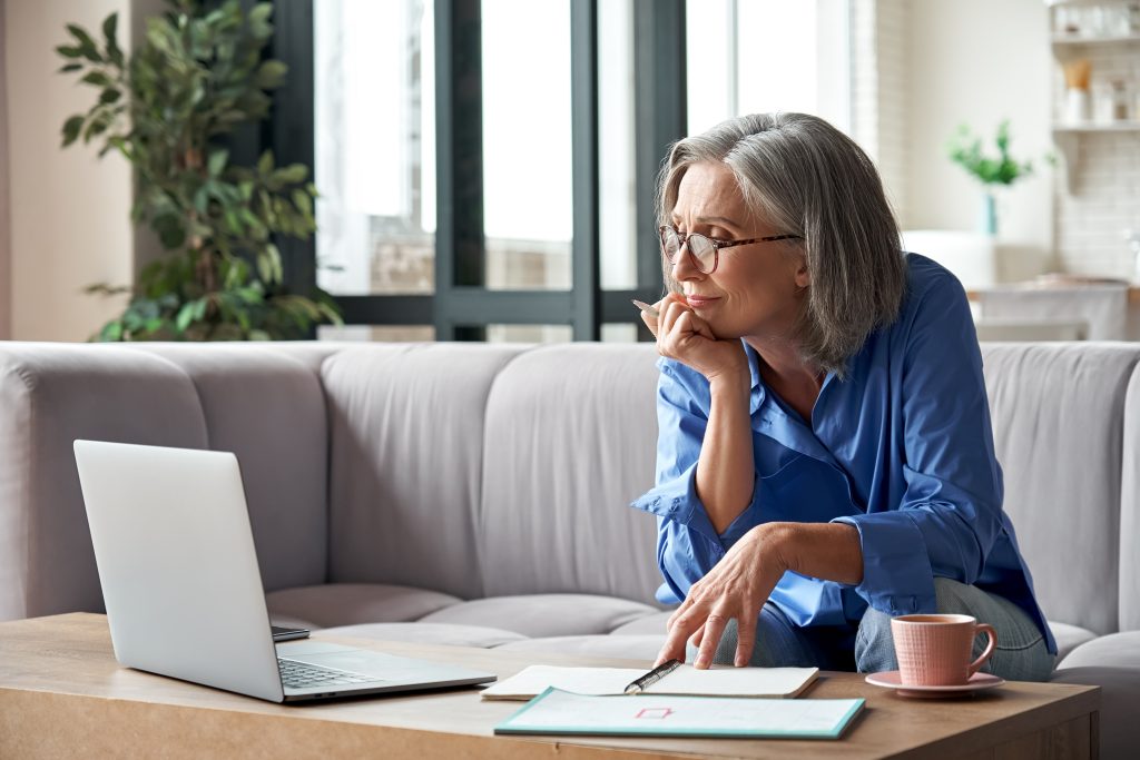 Senior mature older woman watching business training, online webinar on laptop computer remote working or social distance learning from home. 60s businesswoman video conference calling in virtual chat