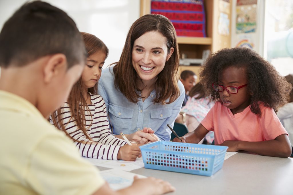 Female elementary school teacher and kids in class, close up